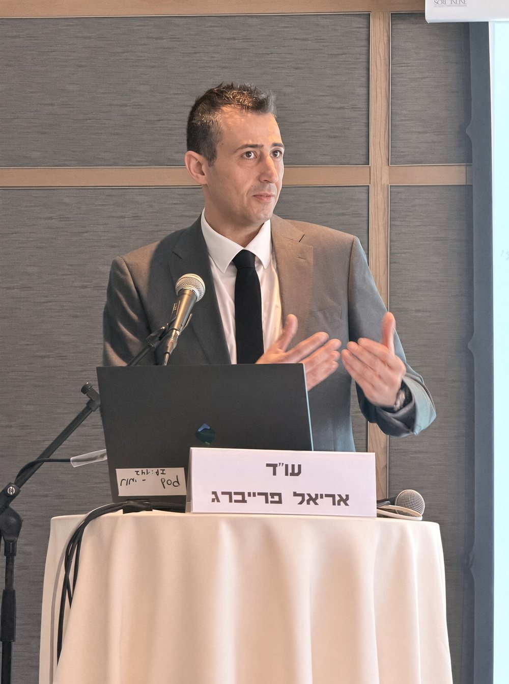 עו״ד אריאל פרייברג מרצה מאחורי הדוכן — משרד עורכי דין אריאל פרייברג ושות׳